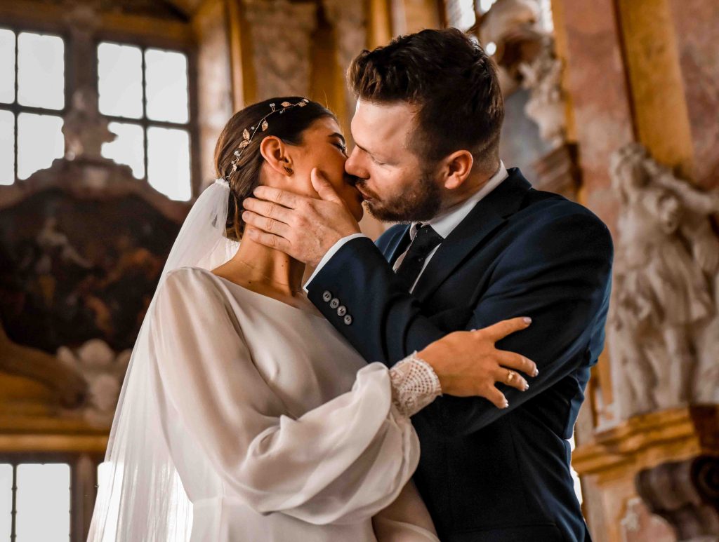 Romantyczny pocałunek pary młodej podczas sesji ślubnej w pałacu – fotografia ślubna