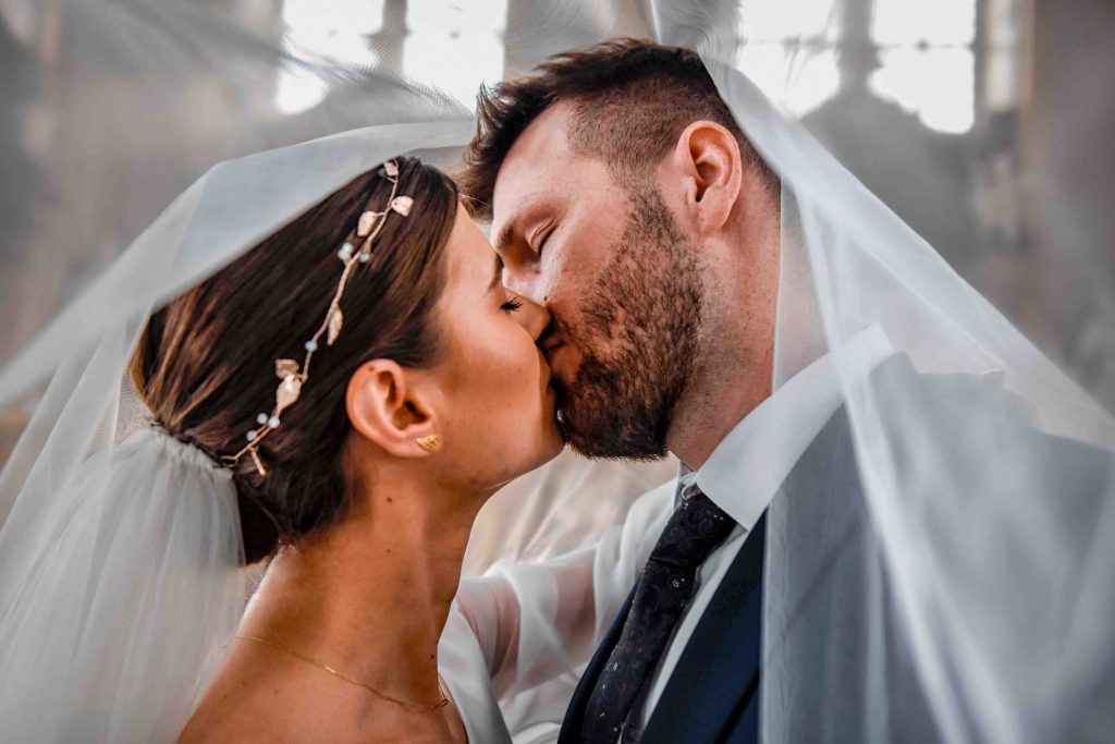 Zbliżenie pary młodej pod welonem – romantyczna fotografia ślubna w pałacu